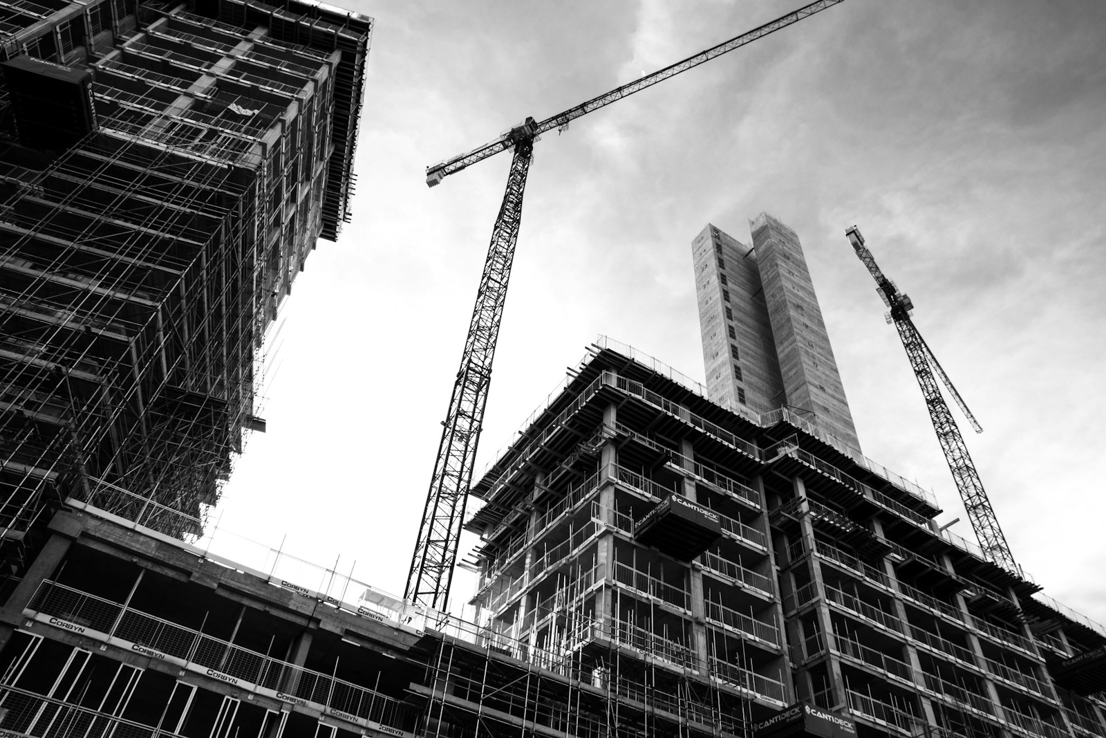grayscale photo of crane in front of building property development