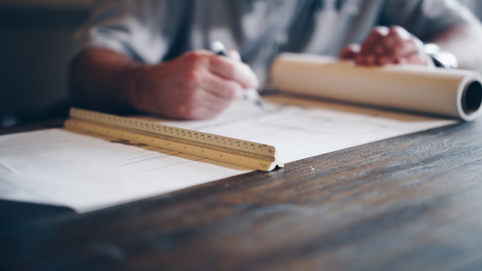 person drafting on blueprint Construction Projects