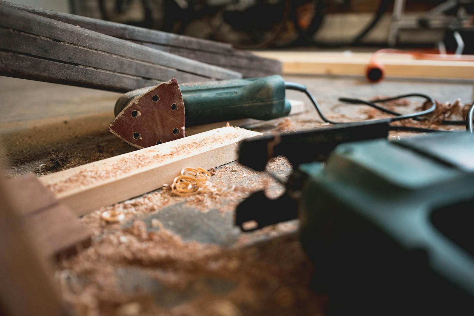 Close-up of various woodworking tools in a workshop, featuring wood shavings and equipment. what is millwork