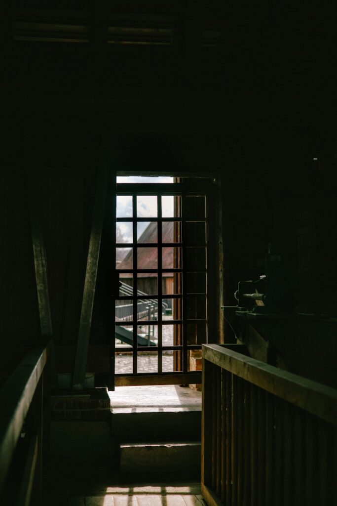 A dark hallway with a window and railing