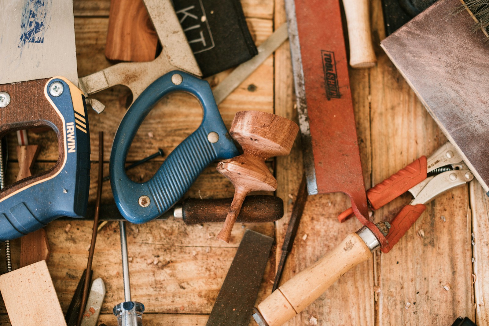 blue and black handle pliers beside brown wooden handle What is a Carpenter