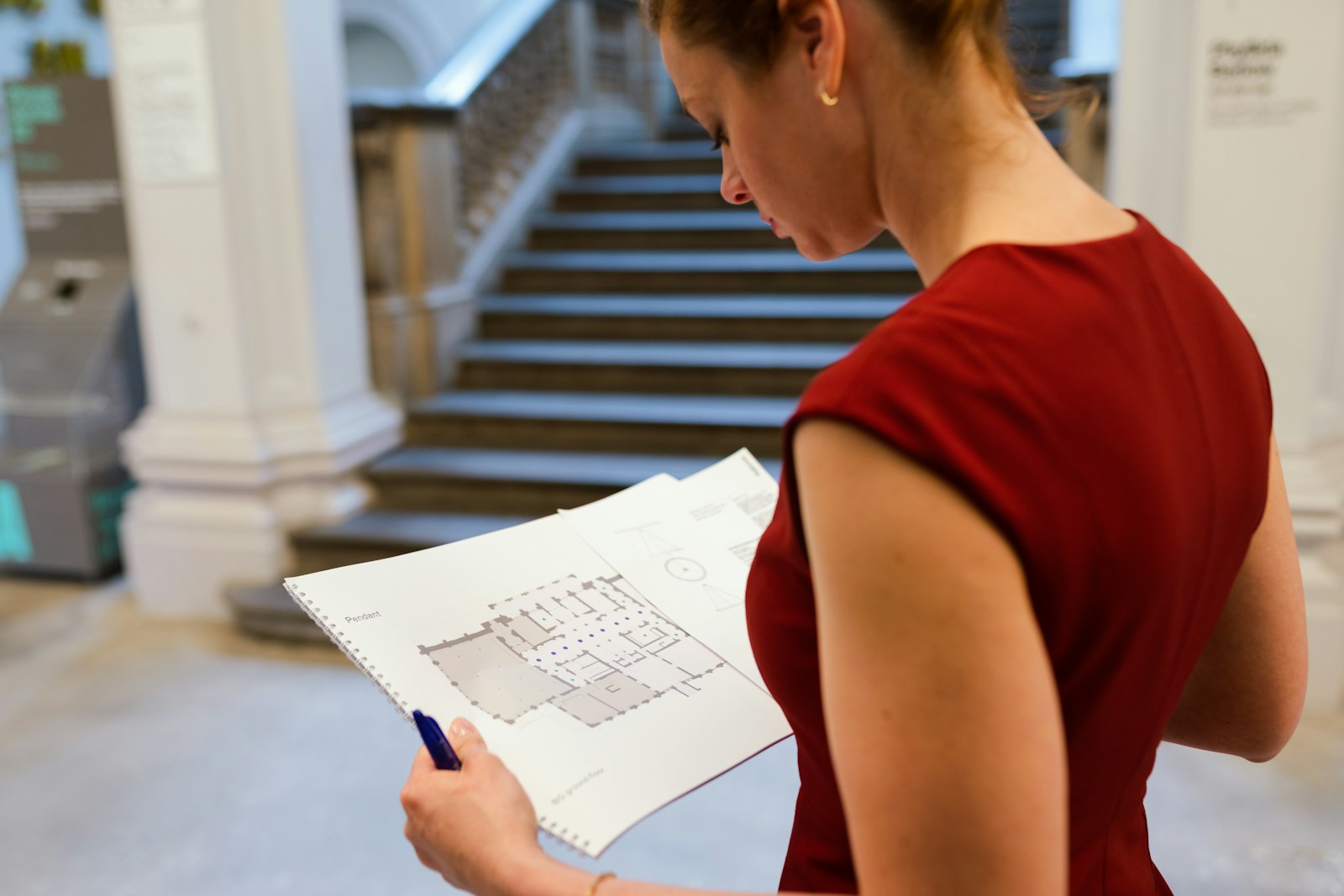 woman in red sleeveless shirt holding white printer paper Design Engineer