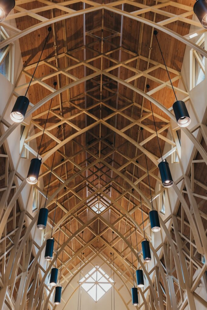 The inside of a building with a ceiling made of wood post and beam