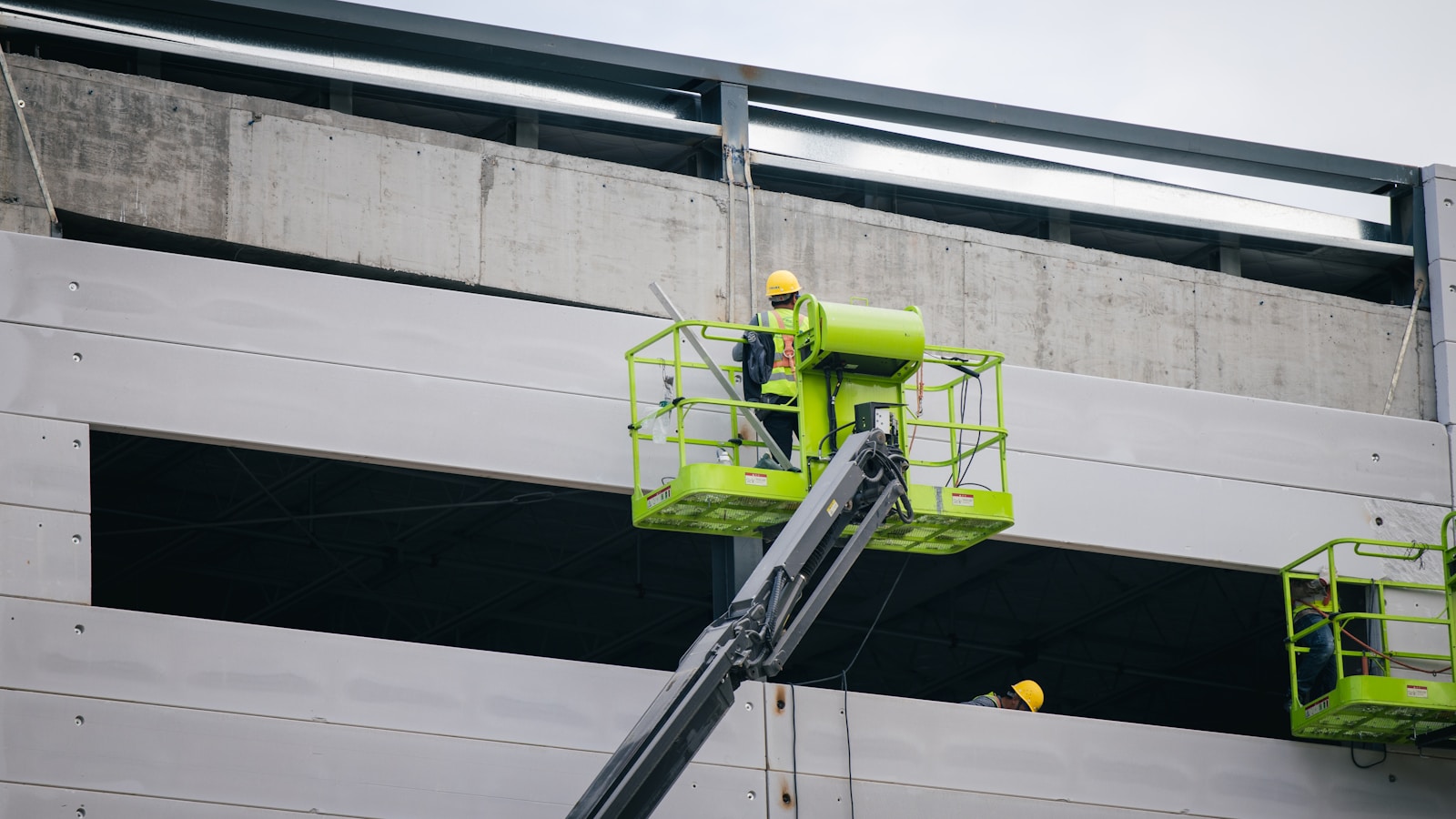 a man on a scissor working on the side of a building construction engineering
