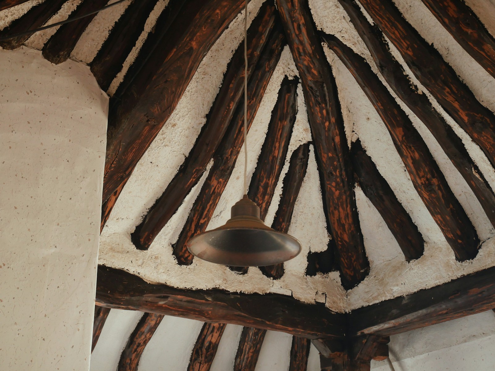 a bell hanging from the ceiling of a building post and beam