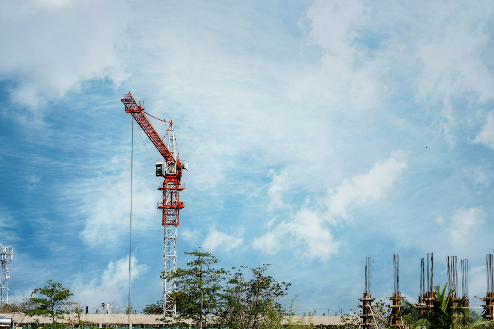 Photo by Arya Krisdyantara Construction crane against a cloudy blue sky. How (design build) Is Shaping the Future of Commercial Construction Projects