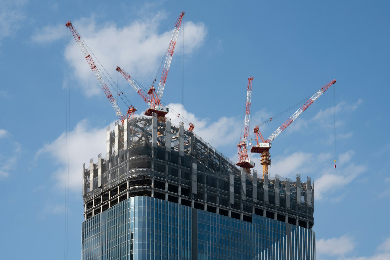 a tall building with cranes on top of it The Essential Role of a (construction project manager) in Complex Commercial Builds
