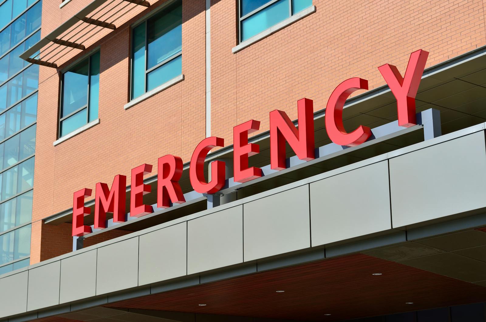 Close-up of a modern hospital emergency room entrance with prominent red letters. Healthcare Facility (Commercial Construction): How It’s Different