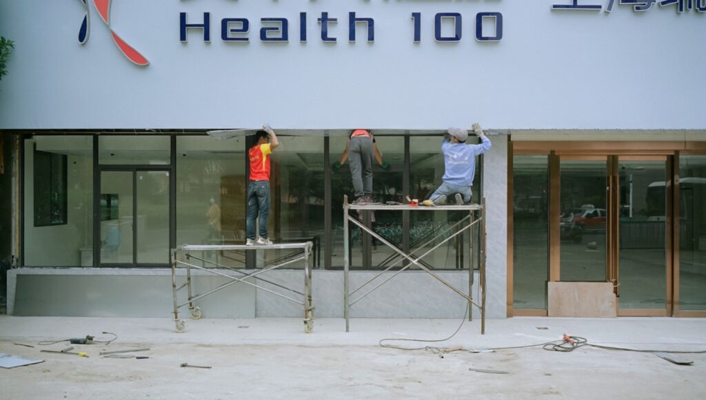 a couple of men standing on a scaffold in front of a building