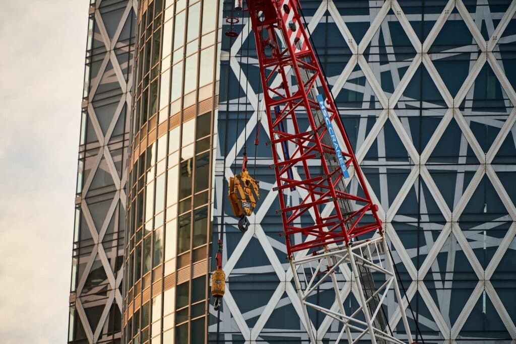 Construction crane against modern glass building