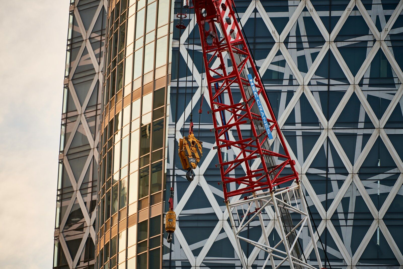 Construction crane against modern glass building