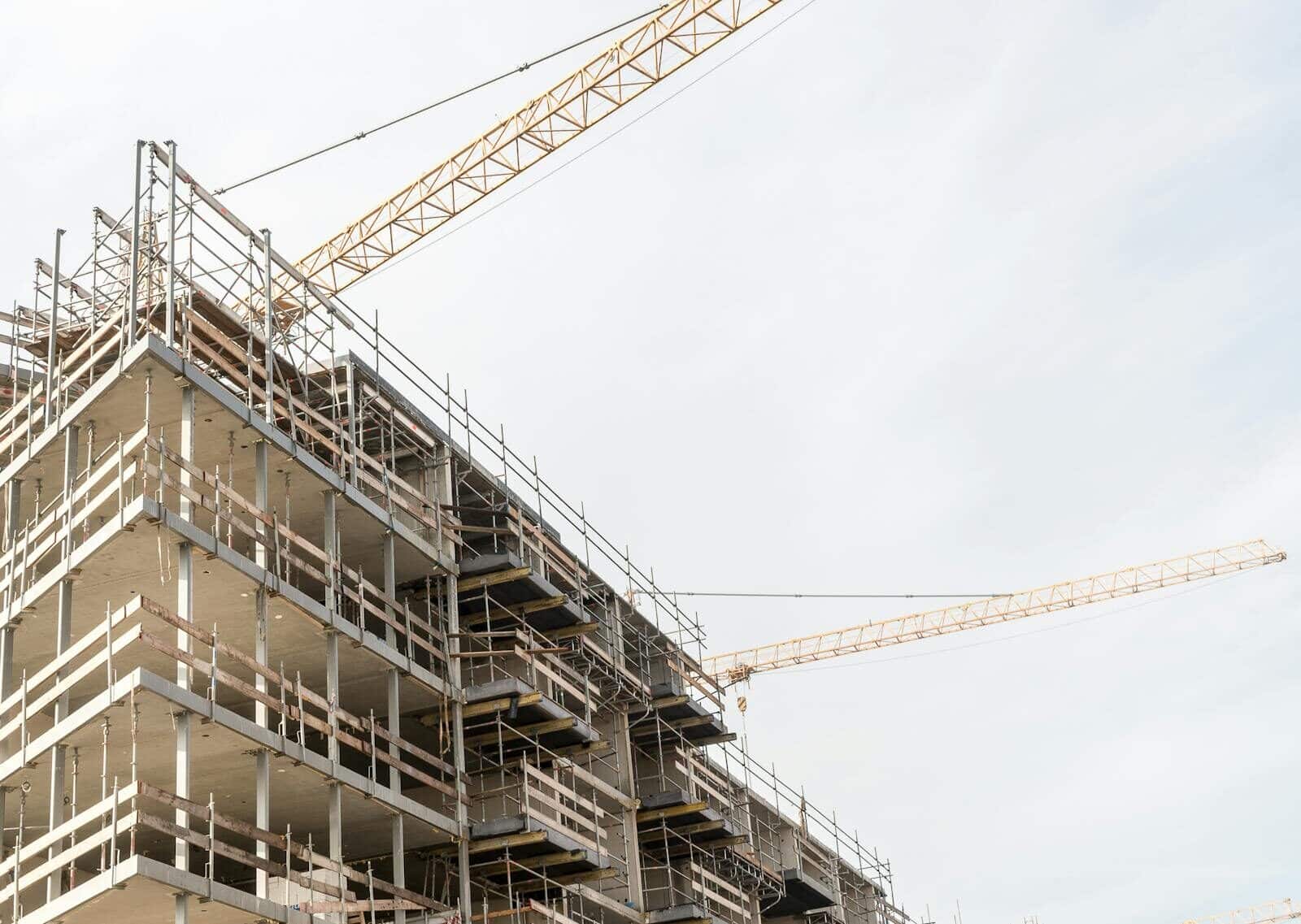 A high-rise building under construction with visible scaffolding and cranes.