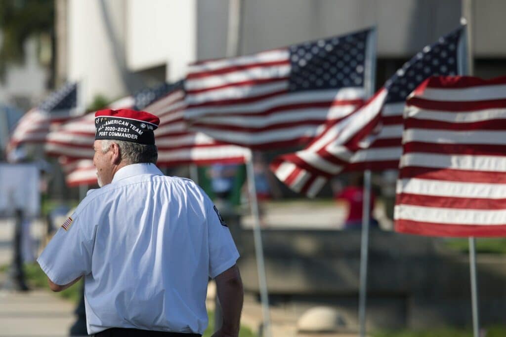 a man standing in front of a row of american flags