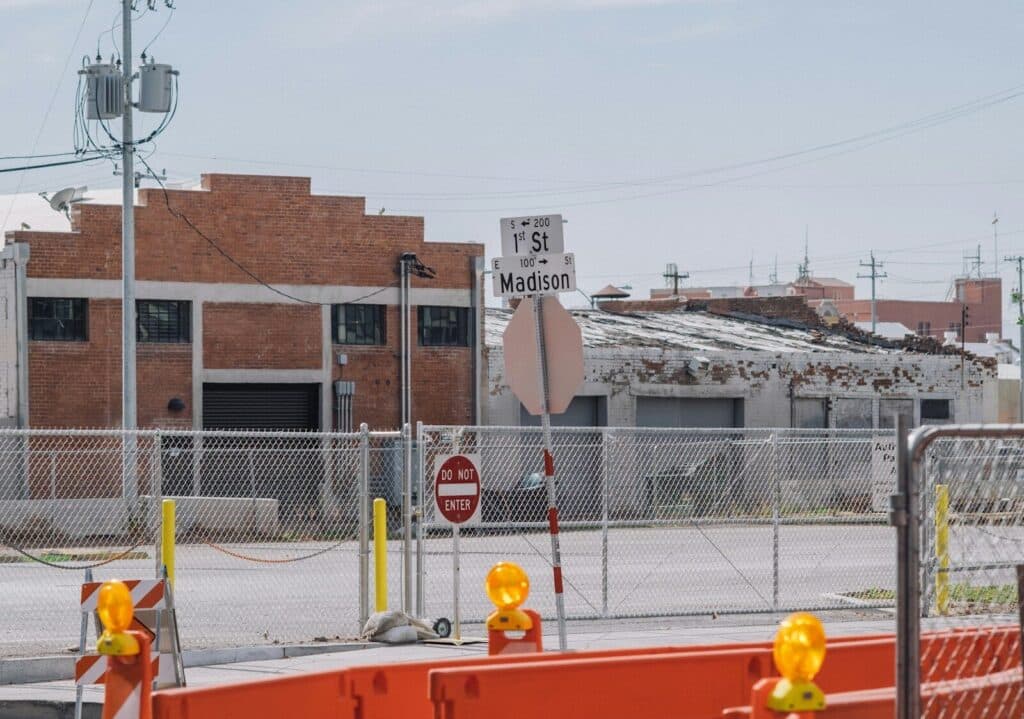 a fenced in area with a building in the background