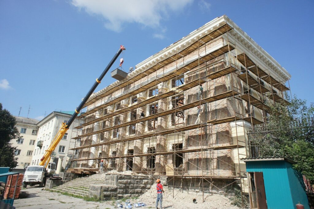 Building undergoing renovation with scaffolding and crane.