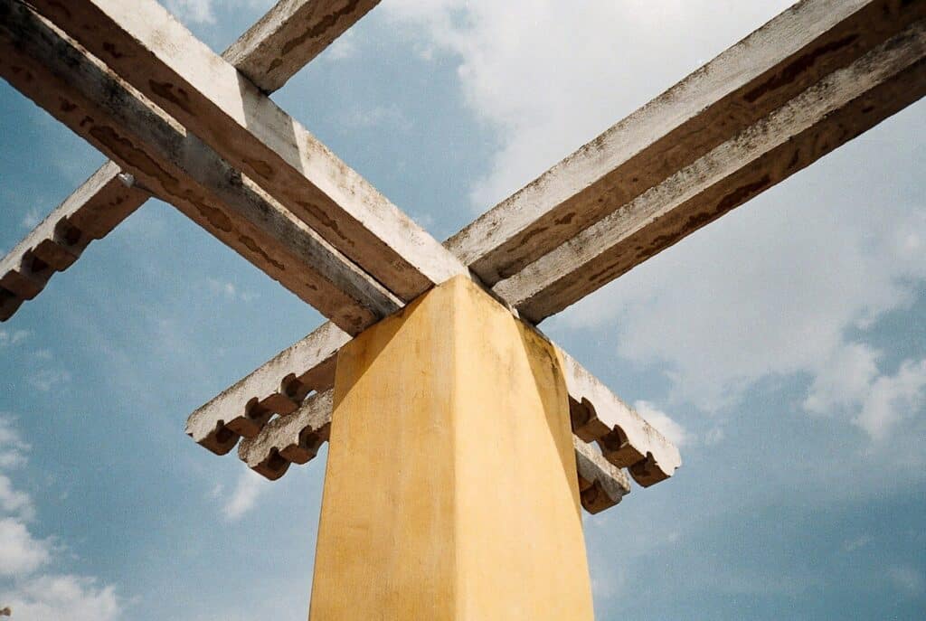 A yellow tie hanging from the side of a wooden structure