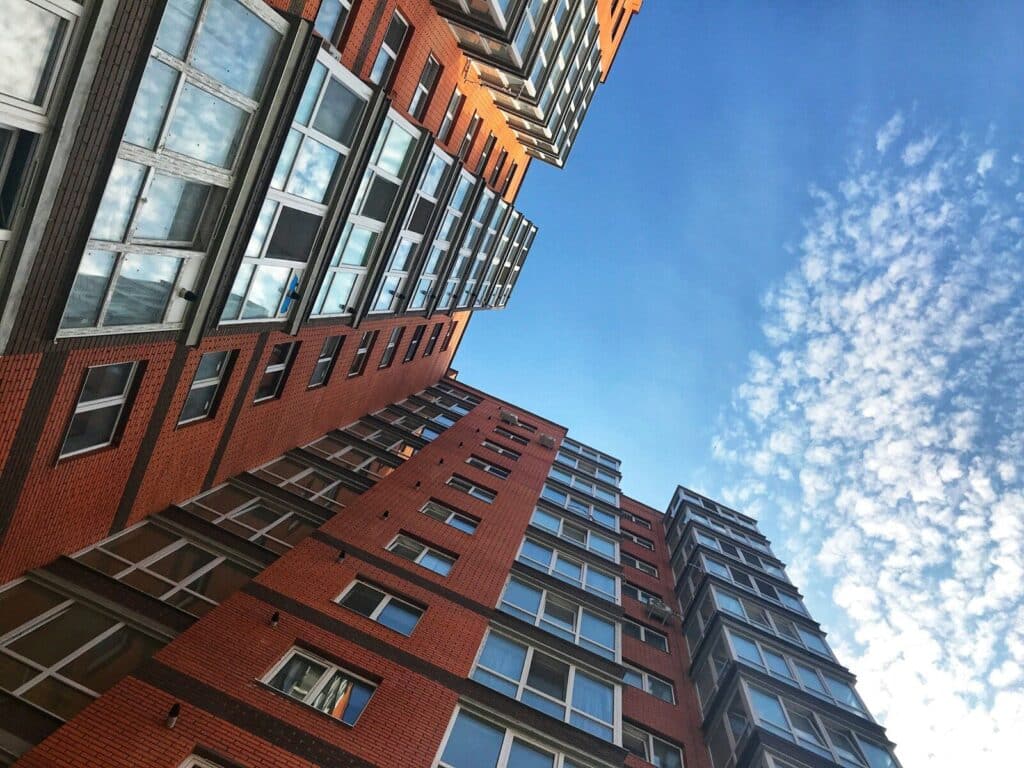 a very tall red brick building next to other tall buildings