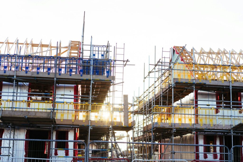 Construction of new houses with scaffolding and framing.