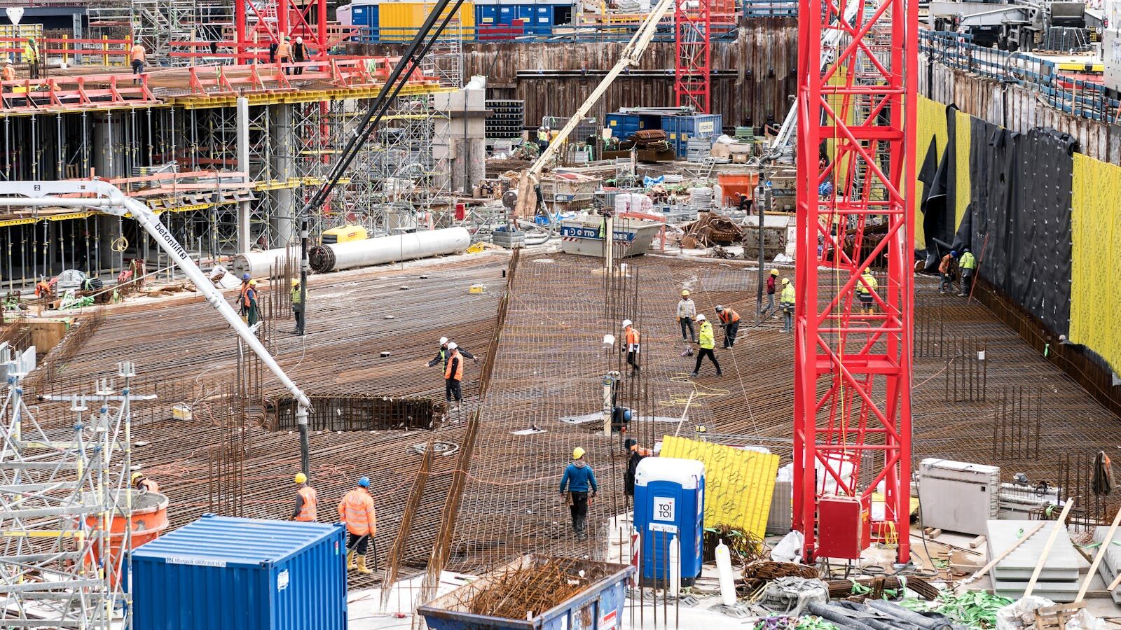 A bustling construction site in Hamburg with workers and equipment actively engaged in building tasks. Project Management Skills Every Successful Construction Team Needs
