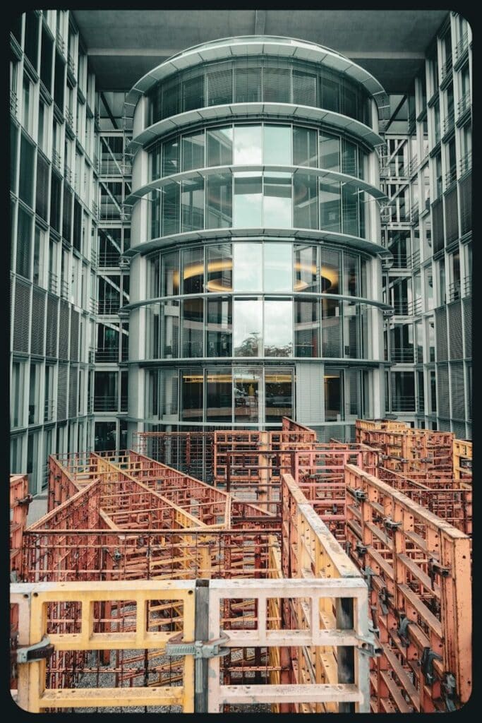 Construction formwork in front of a modern glass building.
