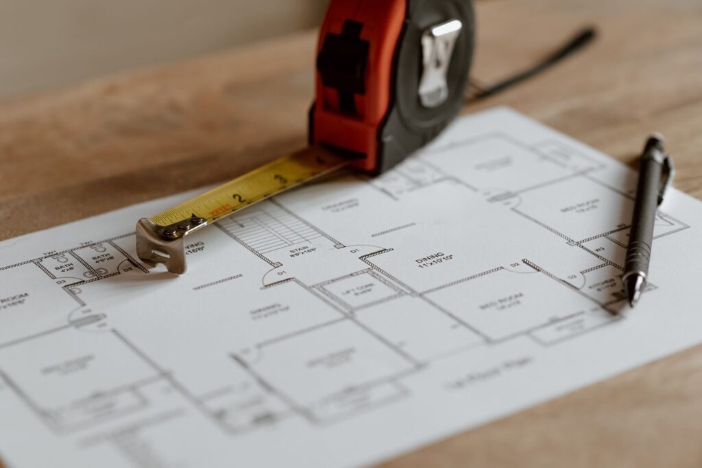 From above of ruler placed near pencil on engineering plan of house during renovation process